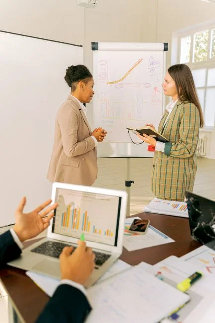 Hands typing on a laptop with cryptocurrency charts and smartphone display in view, focusing on digital finance.